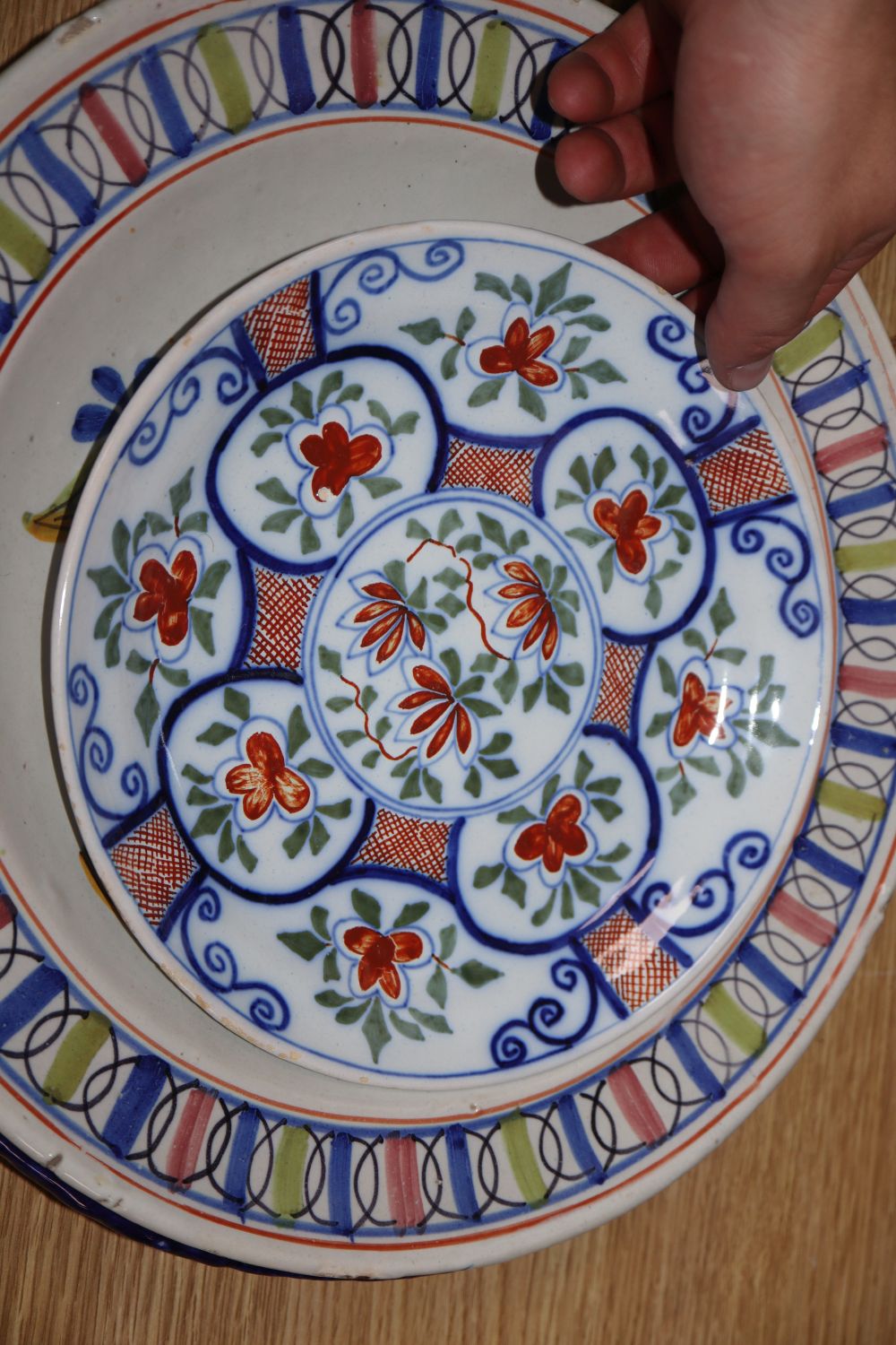 Three tin glazed earthenware dishes and a Persian stone paste vase, height 39cm